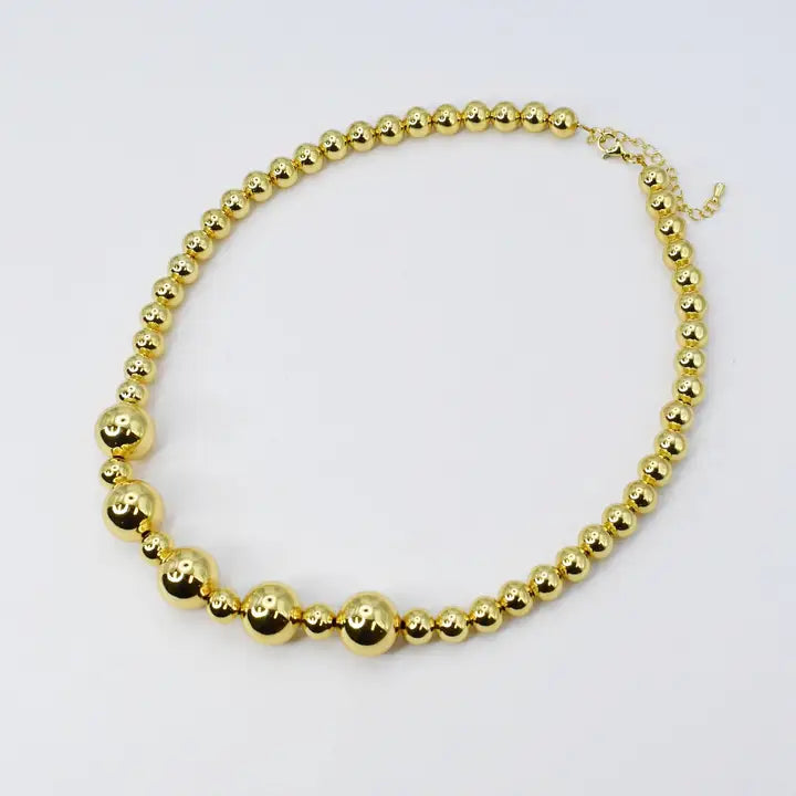 necklace features a variety of gold-plated beads, both small and large, all strung together