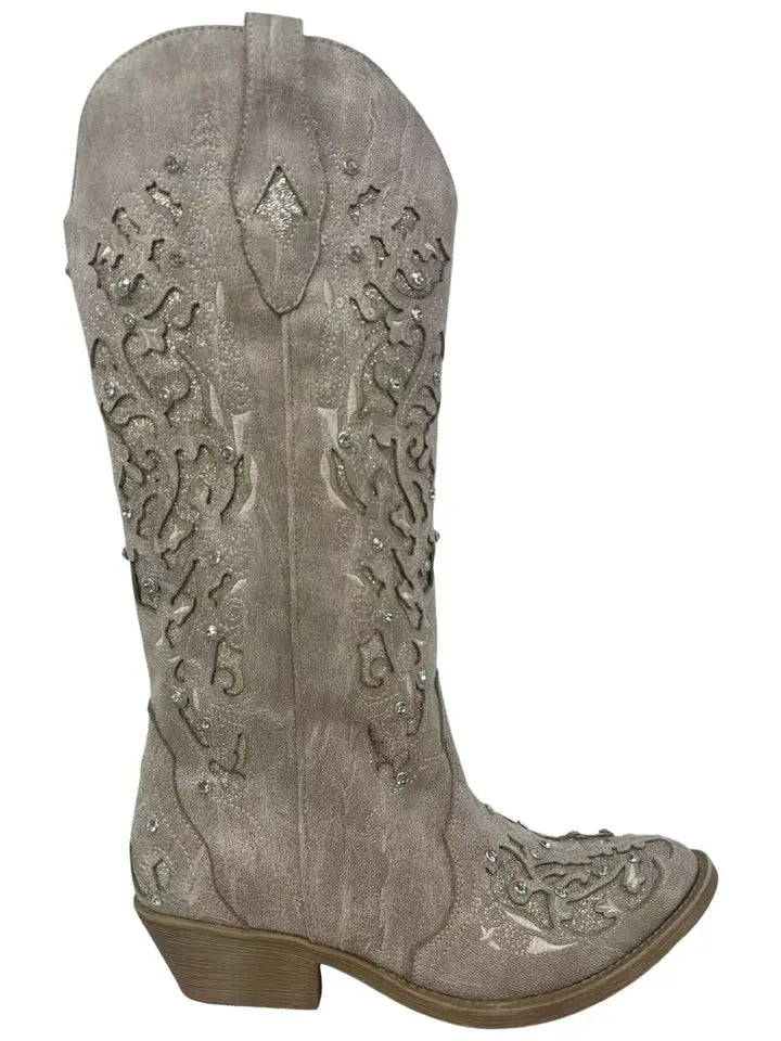 Silver cowboy boot with intricate designs on a white background