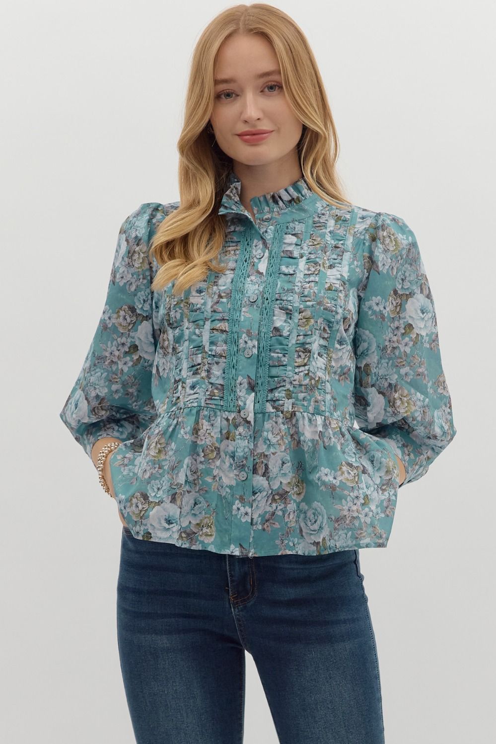 soft teal background, romantic rose print, and rows of ruffle and lace detailing down the front, this blouse brings major vintage vibes with a modern flair