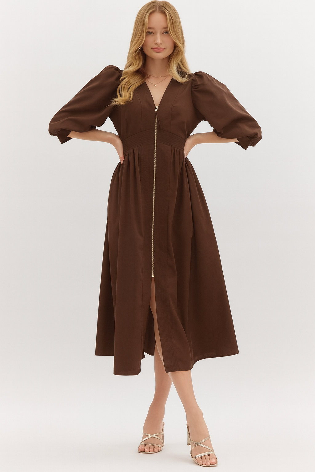 Woman wearing a brown puff sleeve midi dress with a front zipper closure, V-neckline, and flowy skirt