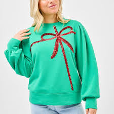 Green sweatshirt with oversized red sequin bow design across the front, balloon sleeves, and relaxed fit