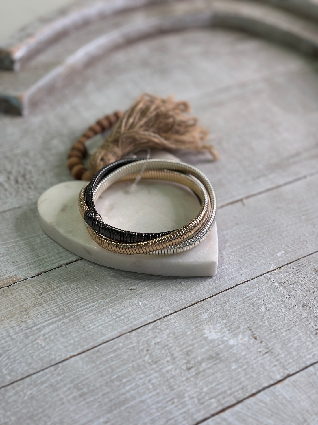 striking trio of bronze, silver, and black-toned bangles designed to stack, shimmer, and stand out.