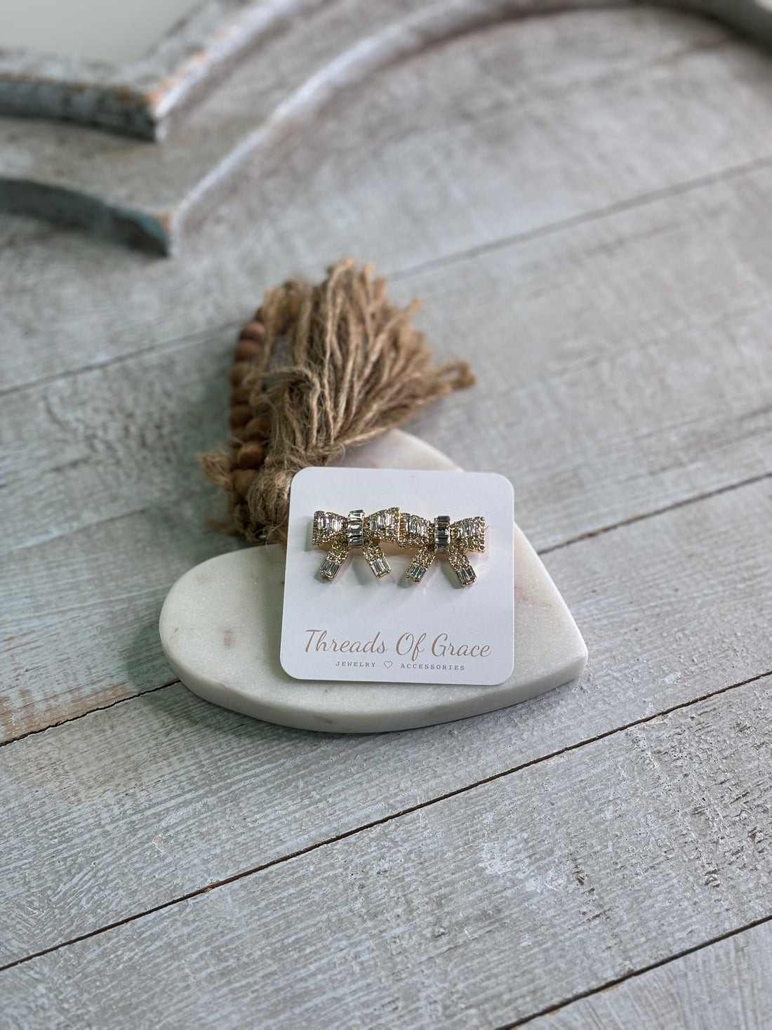 Rhinestone crystal bow stud earrings with a gold tone setting.