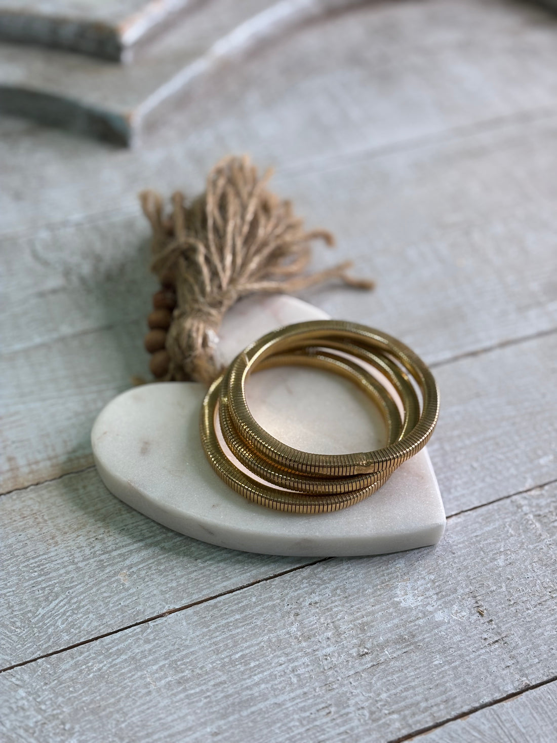 a trio of flexible, gold-toned bangles with a textured coil design.