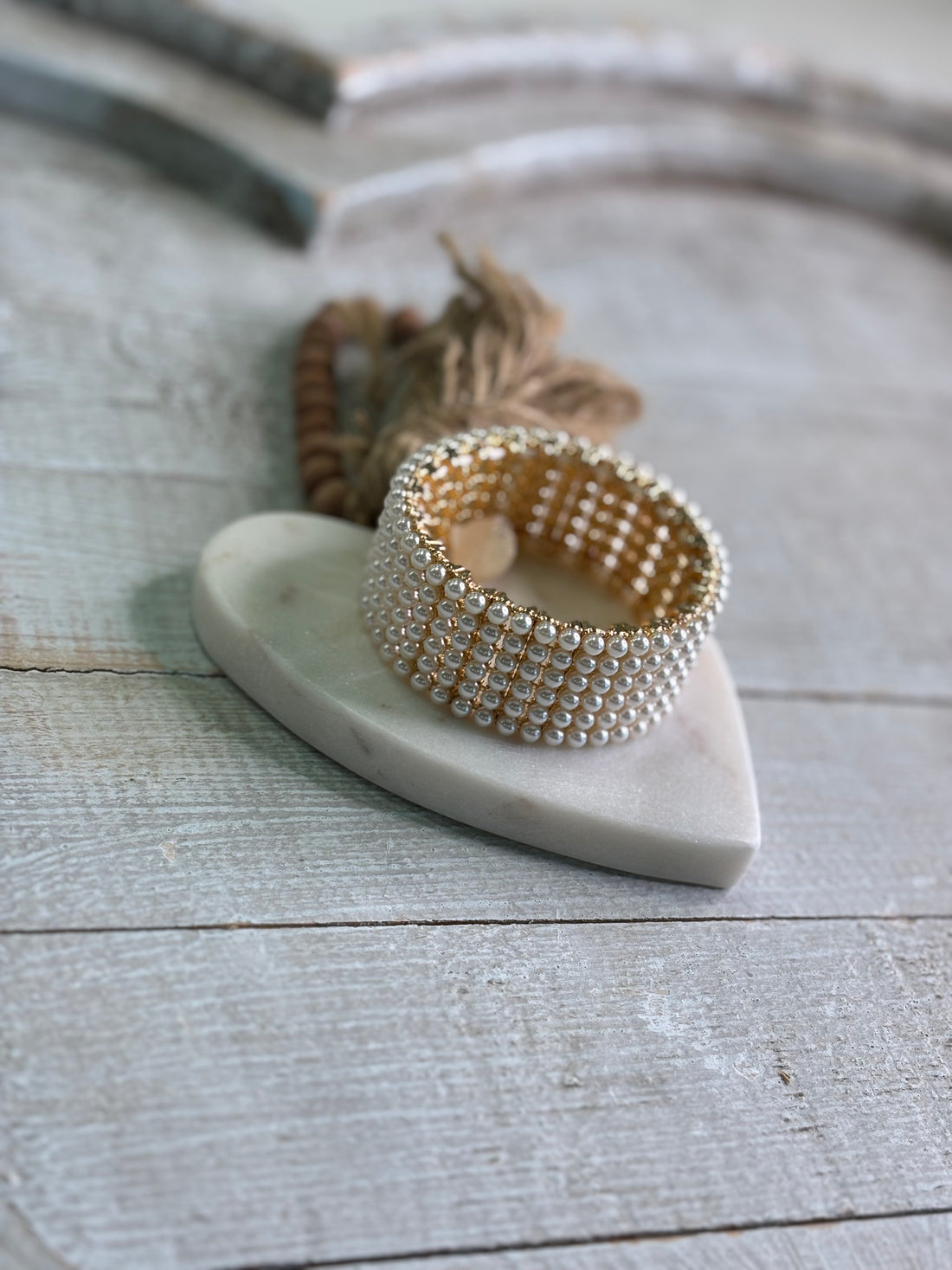 A wide stretch bracelet adorned with rows of glossy faux pearls.
