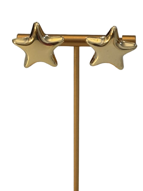 Gold star-shaped earrings on a gray background