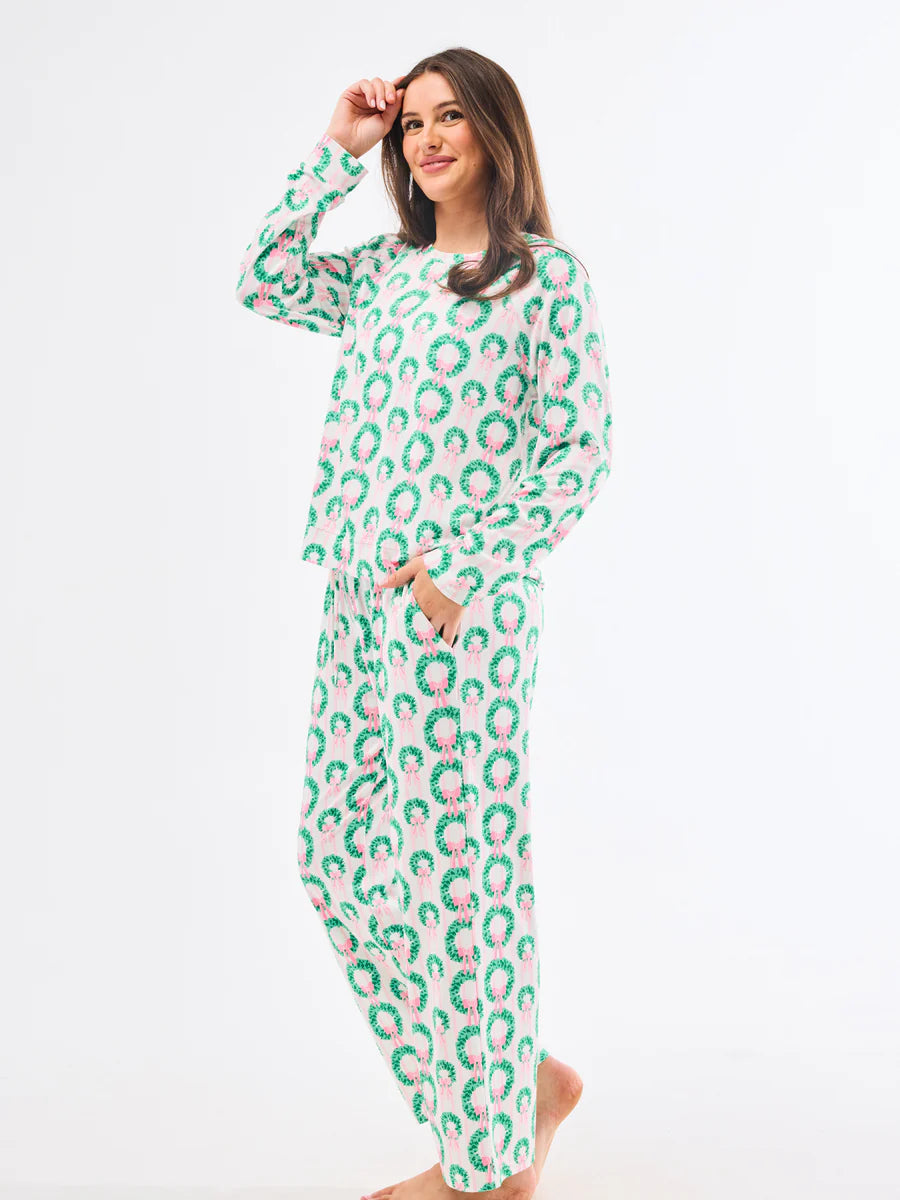 Woman wearing a green and pink patterned onesie on a white background