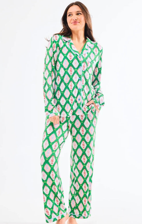 Woman wearing a green and white patterned pajama set on a white background