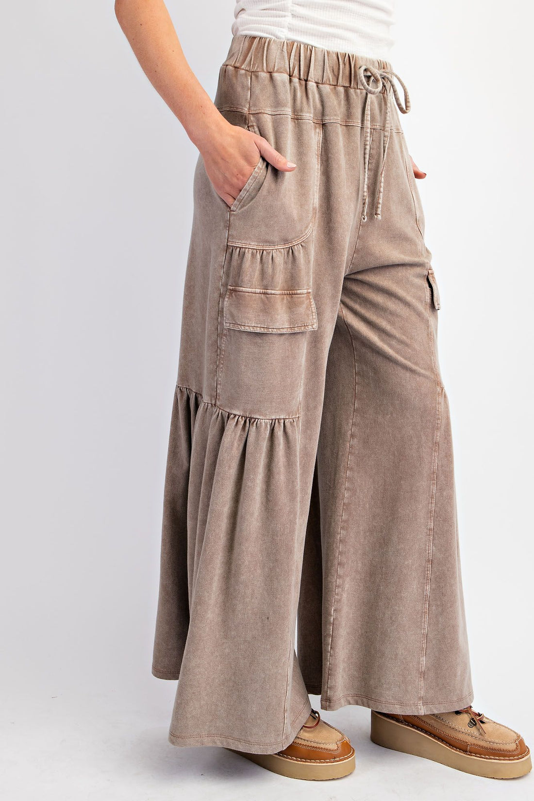 pants feature elastic front tie waistband, side and front pockets, and a wide leg silhouette. Comes in teal and mocha.