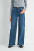 Person wearing blue jeans and a gray shirt on a plain background