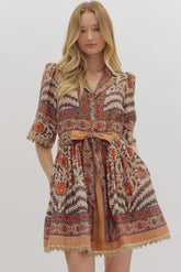 Woman wearing a patterned dress with a belt on a white background