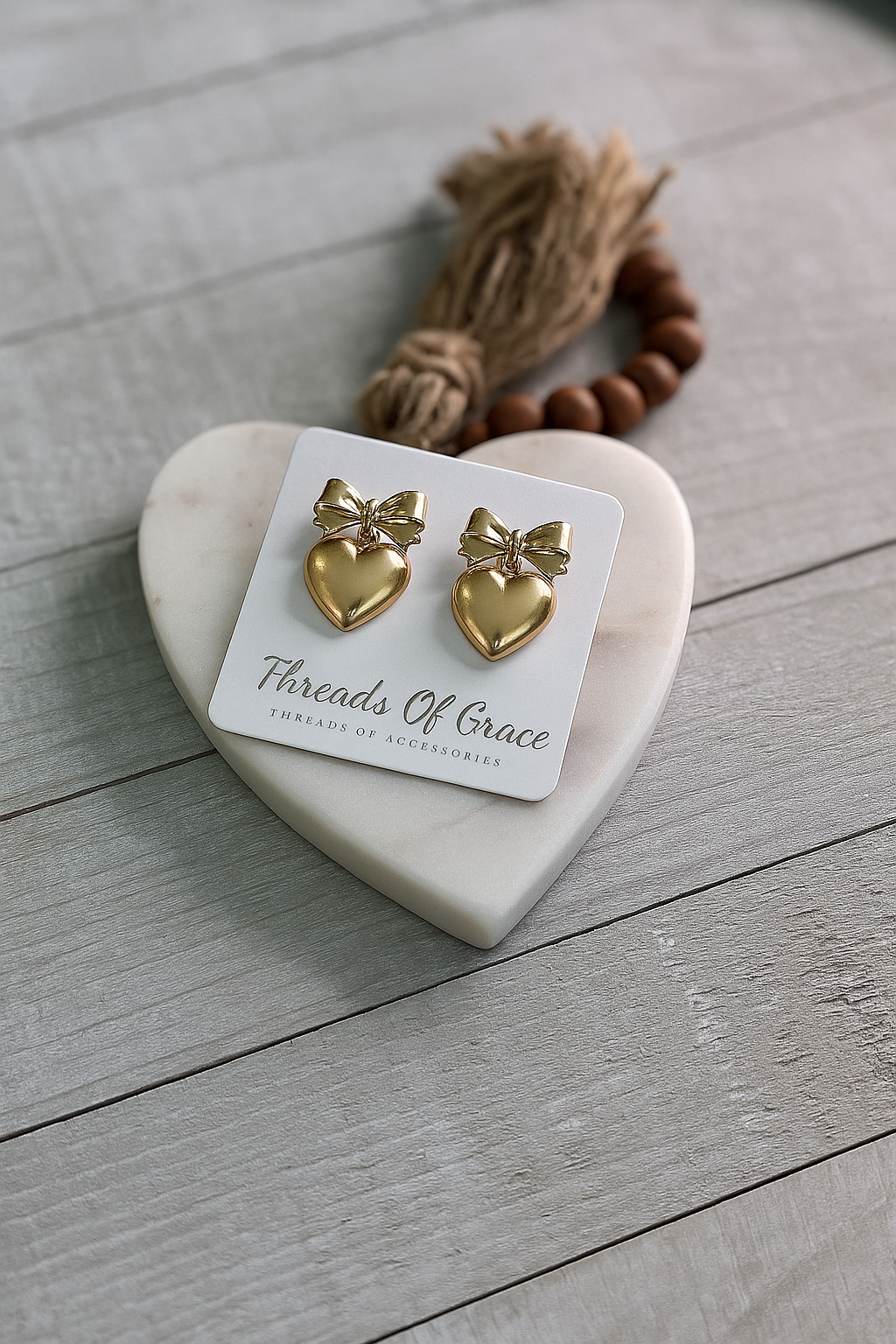 Gold tone heart studs with bow accent.