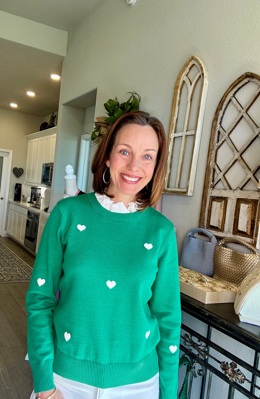 Green long sleeve sweater featuring an embroidered heart design