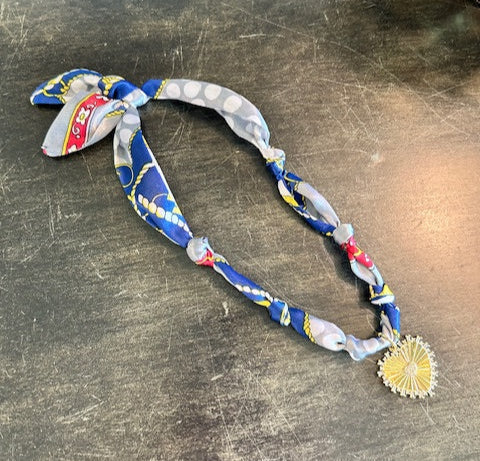 Colorful fabric lanyard with decorative elements on a metallic surface