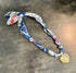 Colorful fabric lanyard with decorative elements on a metallic surface