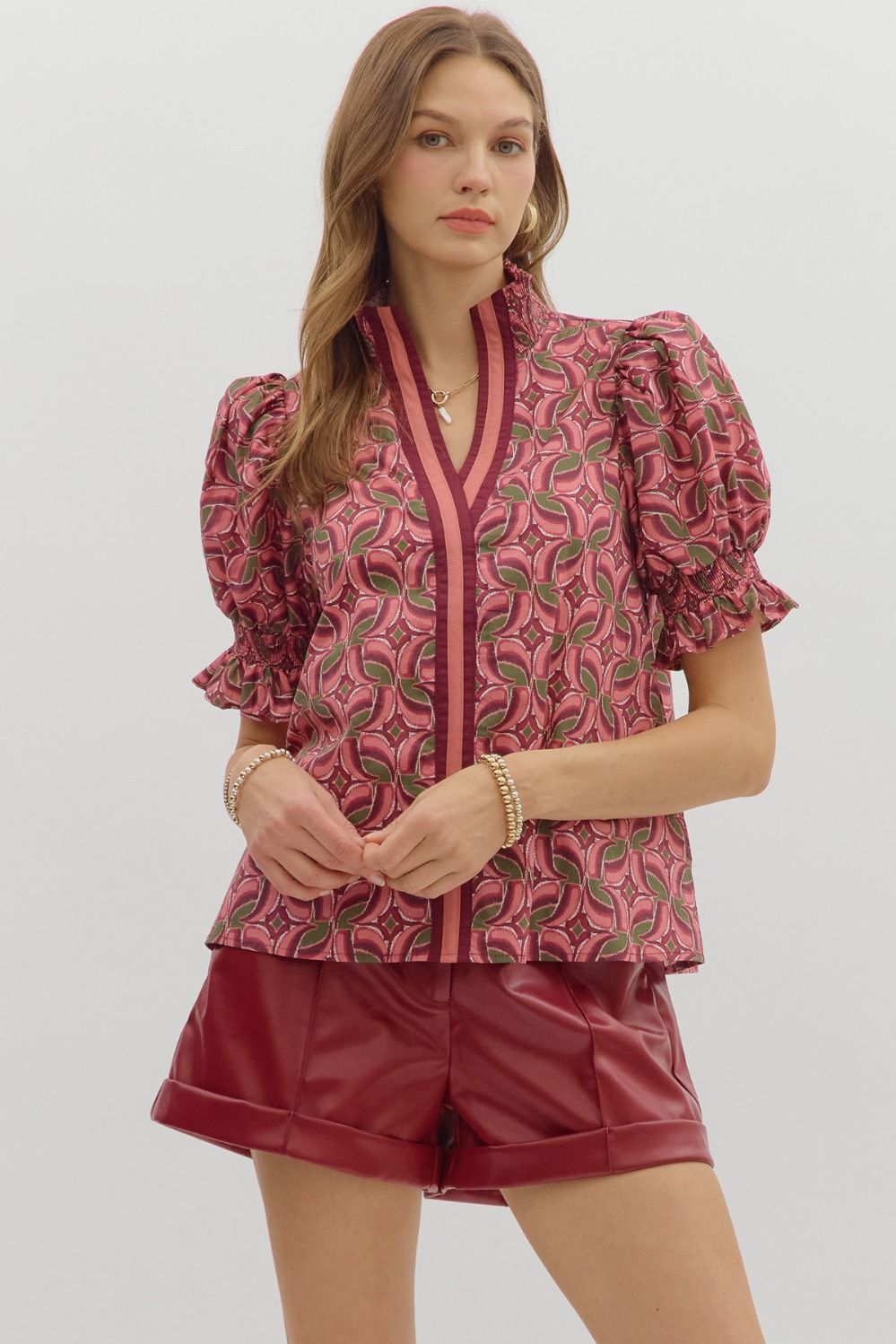 Puff sleeves with smocked ruffle cuffs bring the drama, while contrast trim along the neckline and placket
