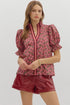 Puff sleeves with smocked ruffle cuffs bring the drama, while contrast trim along the neckline and placket