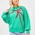 Green sweatshirt with oversized red sequin bow design across the front, balloon sleeves, and relaxed fit