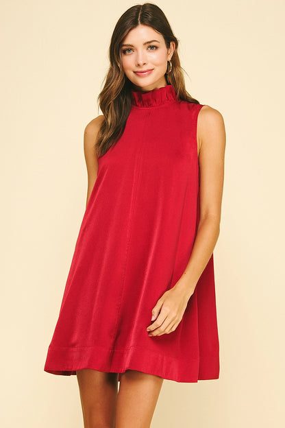 Front view of a red satin sleeveless mini dress with ruffled high neckline.
Back view of a red satin mini dress featuring a large bow tie at the neck.