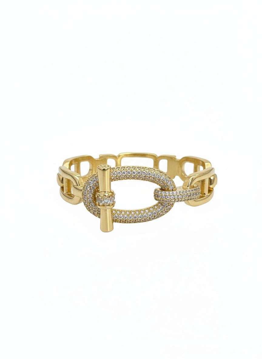 Gold bracelet with diamond accents on a jewelry display card.