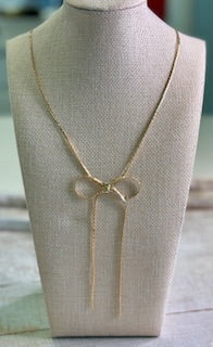 Necklace features a sleek flat gold chain paired with a dainty bow detail that brings just the right amount of charm.