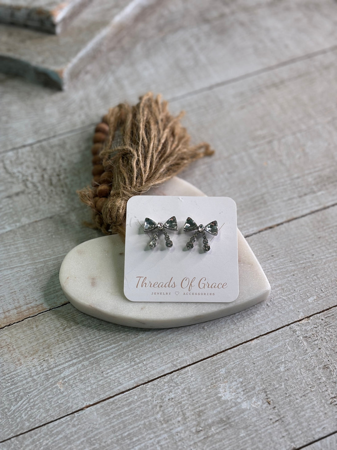 Earrings with a delicate crystal bow design in a silver tone. 