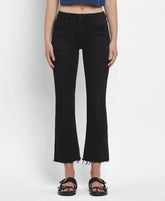Person wearing black flared jeans on a white background