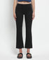 Person wearing black flared jeans on a white background