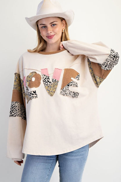 Woman wearing a cream sweater with &