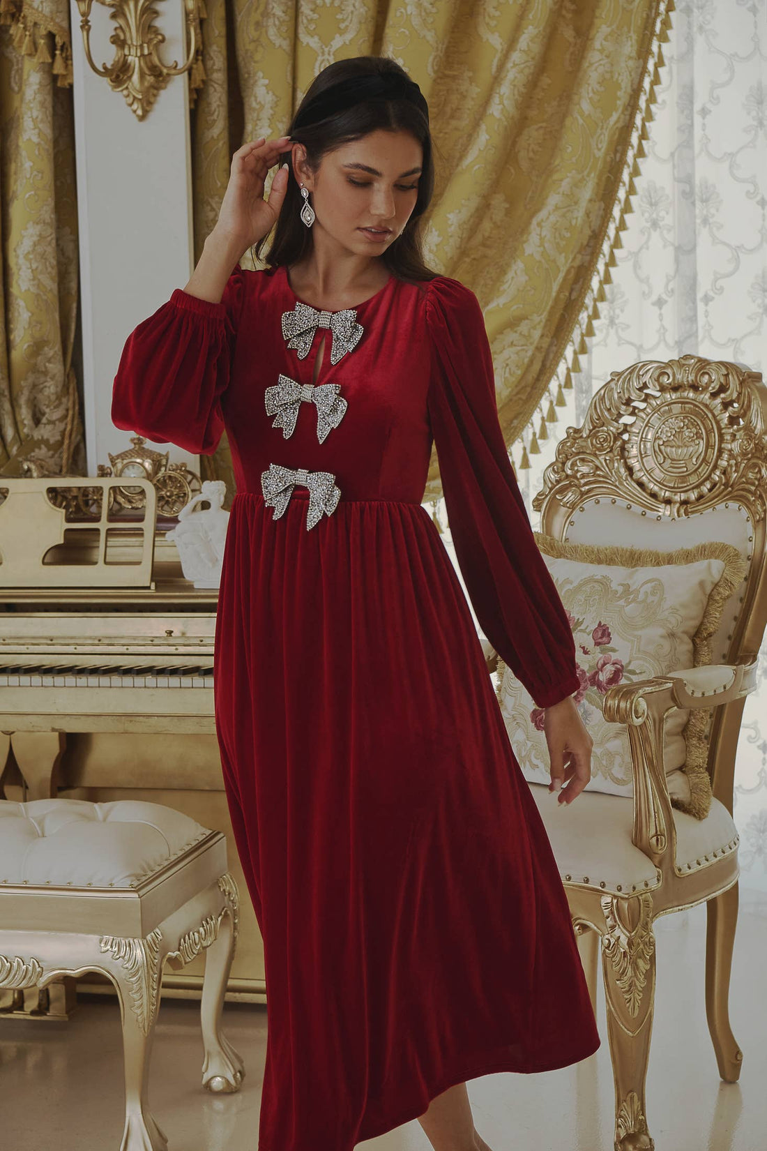 Red velvet long sleeve midi dress with bows on front going down 
