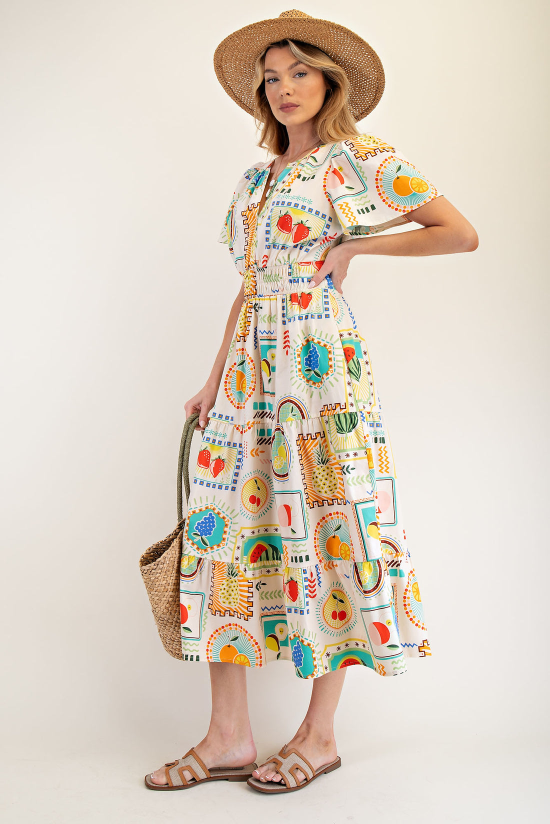 A dress featuring a colorful fruit print on soft cotton poplin, it includes a notched V neckline, a ruched elastic waist, and a tiered midi skirt for a flattering flow. Also had pockets. 