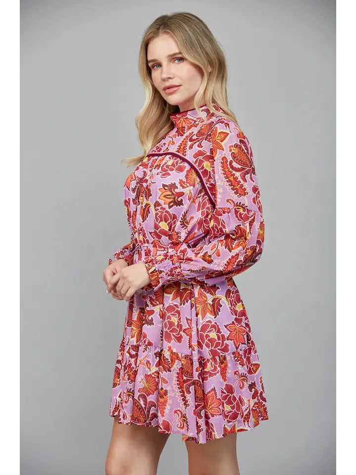 Woman wearing a pink floral dress against a gray background