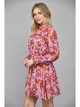 Woman wearing a pink floral dress against a gray background