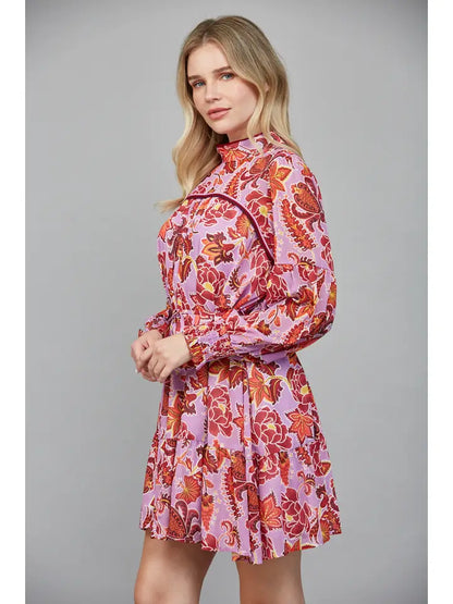 Woman wearing a pink floral dress against a gray background