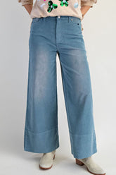 Person wearing blue wide-leg jeans on a plain background