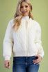 Woman wearing a cream quilted jacket against a green background